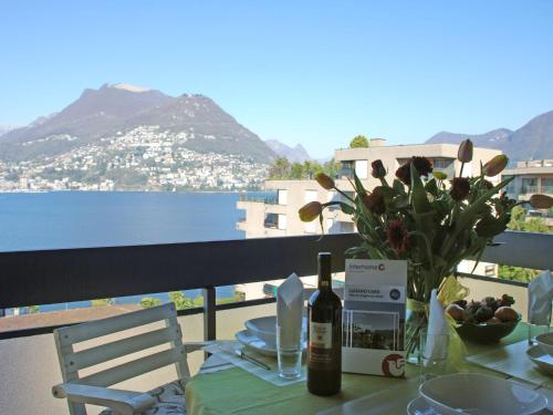 帕拉迪索Apartment App- Paradiso by Interhome的一张桌子,上面放着一瓶葡萄酒和一瓶鲜花