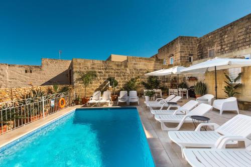 Santa LuċijaSweet Life Gozo的一个带白色椅子和遮阳伞的游泳池