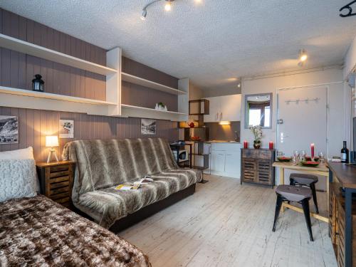 蒂涅Apartment Le Curling B - Val Claret-30 by Interhome的带沙发和书桌的客厅以及厨房。