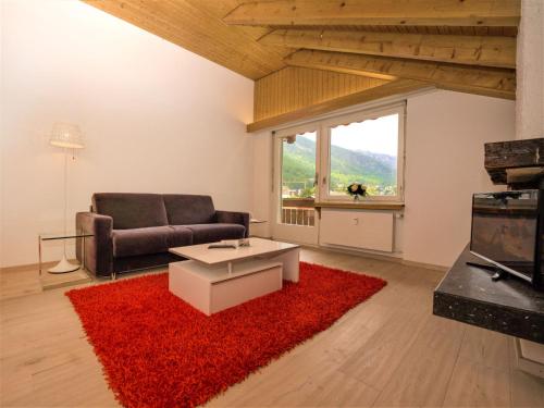 采尔马特Apartment Granit-5 by Interhome的带沙发和红色地毯的客厅