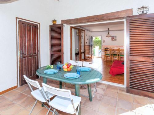 莱斯卡拉Holiday Home La Masia by Interhome的一间设有绿色桌子和白色椅子的用餐室