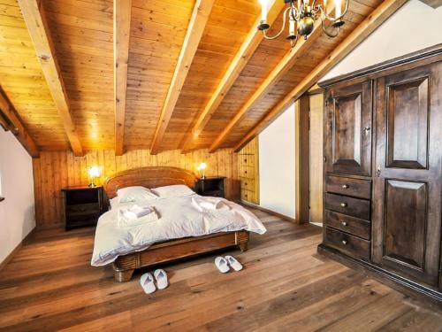 采尔马特Apartment Bergere-1 by Interhome的一间卧室设有一张床和木制天花板
