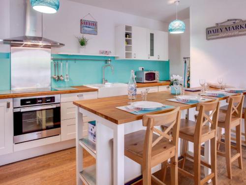 卡布勒通Apartment Cantegrit by Interhome的一间带木桌的厨房和一间带蓝色调的厨房