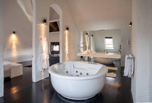 安特卫普B&B Suites FEEK的大型白色浴室设有浴缸和水槽