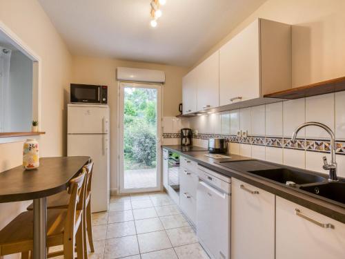 卡布勒通Apartment Tassigny by Interhome的厨房配有白色橱柜、水槽和桌子