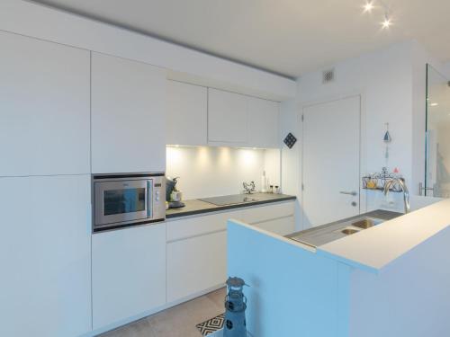 布列登Apartment Residentie sunset by Interhome的厨房配有白色橱柜和微波炉