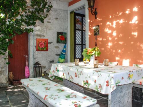 戈尔多拉Holiday Home La Verzaschina by Interhome的一张桌子,上面有白色的桌布,上面有鲜花