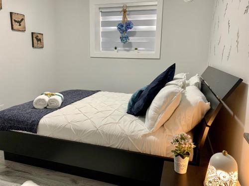 三角洲Luxurious & Stylish Two Bedroom Suite, Full Kitchen, Close to Vancouver的卧室配有带枕头的床铺和窗户。