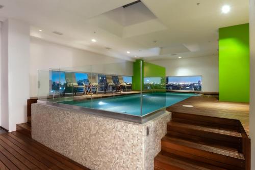 墨西哥城挪威特酒店的一座带绿色墙壁的别墅内的游泳池