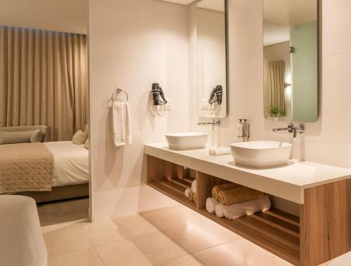 AmsterdamhoekBluewater Bay Sunrise Hotel的一间带两个盥洗盆和一张床的浴室