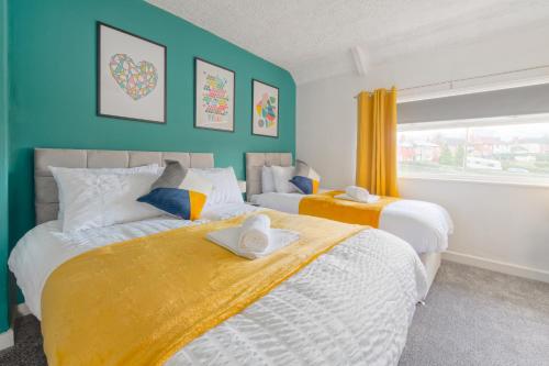 KillingbeckRookwood house Modern spacious home W/free parking的卧室设有两张床,拥有蓝色的墙壁和窗户。