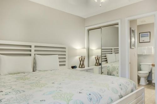 德斯坦10 C One Bedroom Condo的白色卧室设有一张大床和卫生间