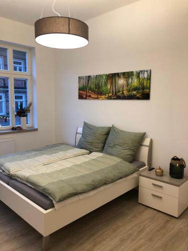 布兰肯堡Altstadtjuwel的卧室配有一张床,墙上挂有绘画作品
