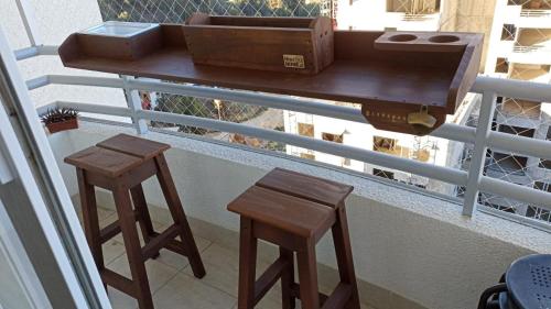 维纳德马Departamento Nuevo en Condominio Viña del Mar的阳台上的一张桌子和两张凳子,上面有行李箱