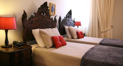维亚纳堡卡萨曼努埃尔奥利维拉酒店的一间卧室配有两张带红色枕头的床