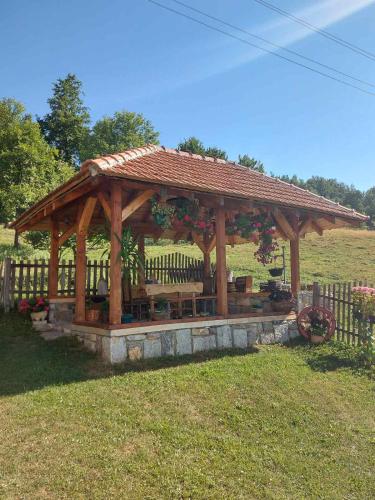 新瓦罗什Domaćinstvo Sindžirević的木制凉亭,在田野上设有长凳