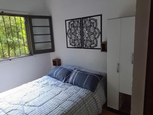 库奇拉阿尔塔Arazá的一间卧室配有一张带蓝色枕头的床和一扇窗户。