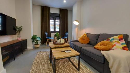 马拉加Apartamento Golddem City的客厅配有沙发和桌子