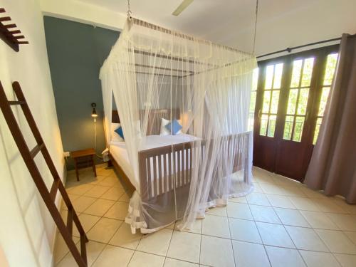 乌纳瓦图纳Unawatuna Nor Lanka Hotel的客房内的带蚊帐的婴儿床
