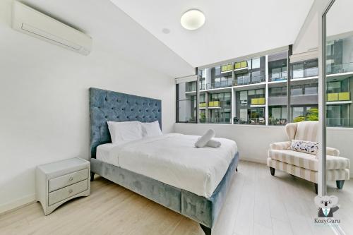 悉尼KOZYGURU MASCOT 2 BED APT FREE DOUBLE-PARKING NMA629的一间卧室配有一张大床和一把椅子