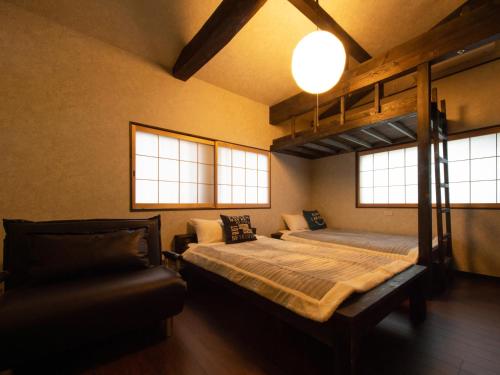 高野山Guest House Suzumeno Kakurembo的一间卧室配有双层床和沙发