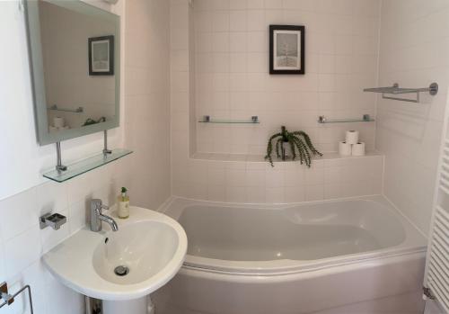 赛伦塞斯特Harrier Lodge的白色的浴室设有浴缸和水槽。