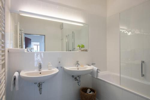 米特尔贝格瓦尔顶门格豪恩旅馆的浴室设有2个水槽、浴缸和镜子