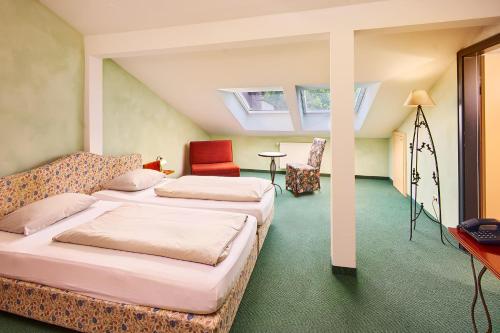 巴特法伊尔恩巴赫凯斯乐威尔特乡村酒店的一间卧室配有两张床、一张桌子和一把椅子