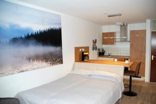 恩茨克勒斯特勒Ferienwohnung mit Aussicht的一间卧室配有一张床、一张书桌和一幅画