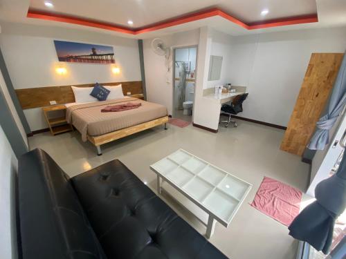 班泰CheeVa Beach Resort的一间卧室配有一张床、一张桌子和一张沙发