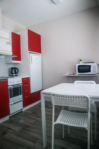 科沃拉Stay Kymi kalustetut huoneistot的厨房配有红色橱柜和白色的桌椅