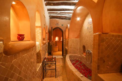马拉喀什Riad Palais Des Princesses & Spa的浴室配有浴缸和红色花卉淋浴