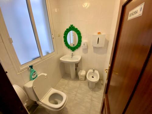 莱昂Hostal Alvarez的一间带卫生间、水槽和镜子的浴室