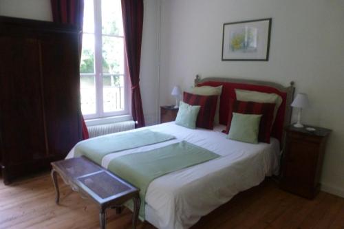奥登河畔的布雷特维尔Chambres d'Hôtes Le Bas Manoir的一间卧室设有一张大床和一个窗户。