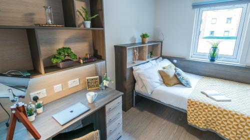 曼彻斯特Homely Private Bedrooms at Oxford Court in Manchester的一间卧室配有书桌、床和书桌、四柱床。