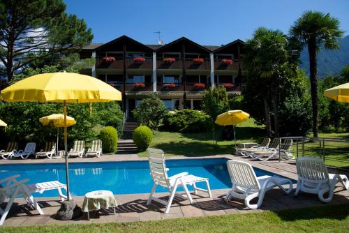 梅拉诺坦内霍夫酒店的酒店前方的游泳池配有椅子和遮阳伞
