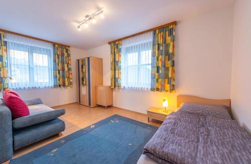 埃本塞Ferienwohnung Kogelblick的一间卧室配有一张床、一张沙发和窗户。