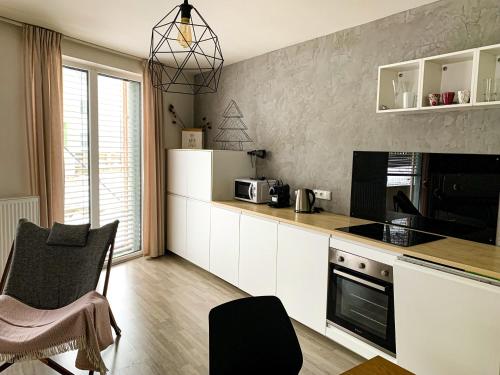 多克西Jezerní apartmán s terasou a saunou v Lakepark Residence的厨房配有白色橱柜和台面