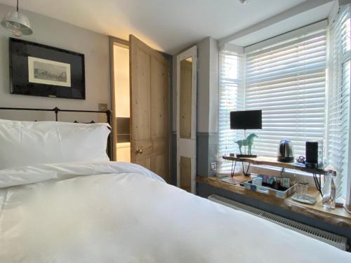 布莱顿霍夫27 Brighton Guesthouse的卧室设有一张白色大床和一扇窗户。