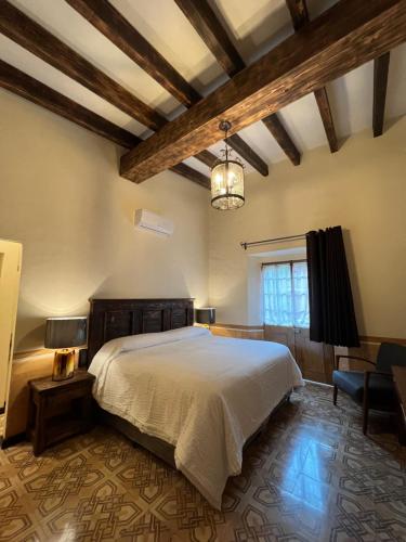 库埃纳瓦卡Mesón de las Delicias的一间卧室配有一张大床和一个吊灯。