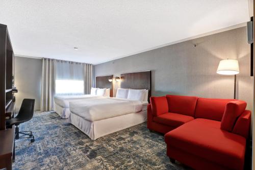 米西索加福朋喜来登多伦多密西沙加酒店的酒店客房带两张床和一张红色沙发