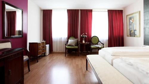 维也纳Hotel Attaché contactless的酒店客房设有一张床、一张书桌和窗户。