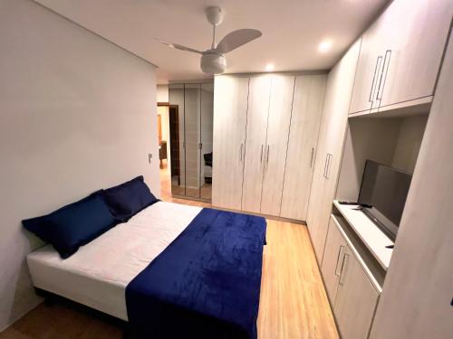 大普拉亚Apartamento 82 - Guilhermina的一间卧室配有一张床和一台平面电视