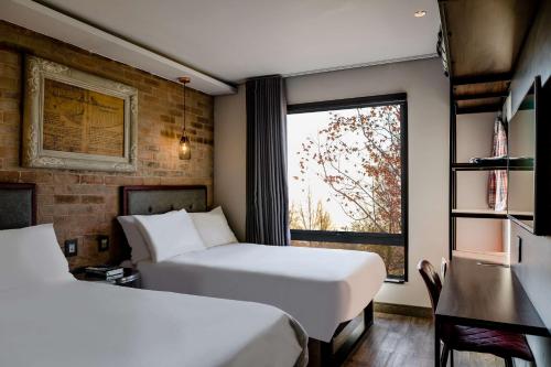 约翰内斯堡Hotel Perte at Montecasino的酒店客房设有两张床和窗户。