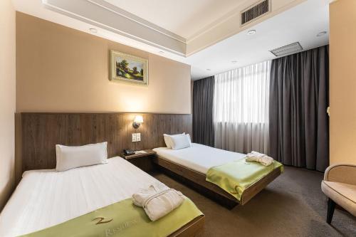 阿拉木图雷尼翁酒店的酒店客房,设有两张床和一张沙发