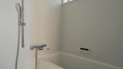 尾道市HUB INN的设有带浴缸和淋浴的浴室。