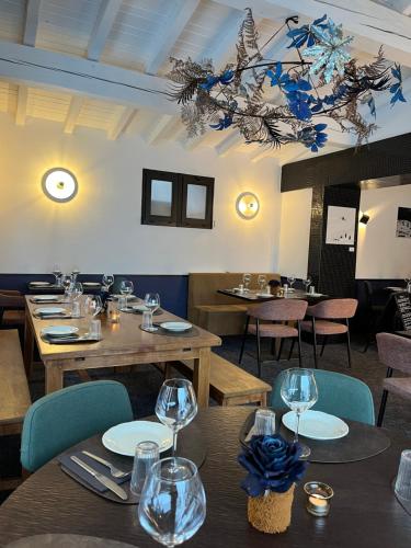斯姿Relais Des Villards的餐厅设有木桌、椅子和吊灯。
