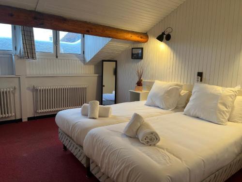 斯姿Relais Des Villards的一间卧室配有两张带白色床单和枕头的床。