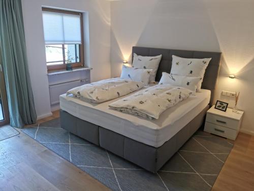 巴特欣德朗Ferienwohnung Wiesenblick的卧室配有一张带白色床单和枕头的大床。