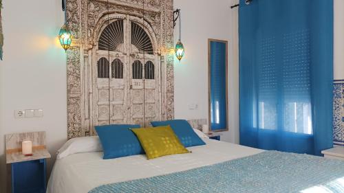 埃尔加斯托尔El Duende del Tejar的一间卧室配有蓝色和黄色枕头的床